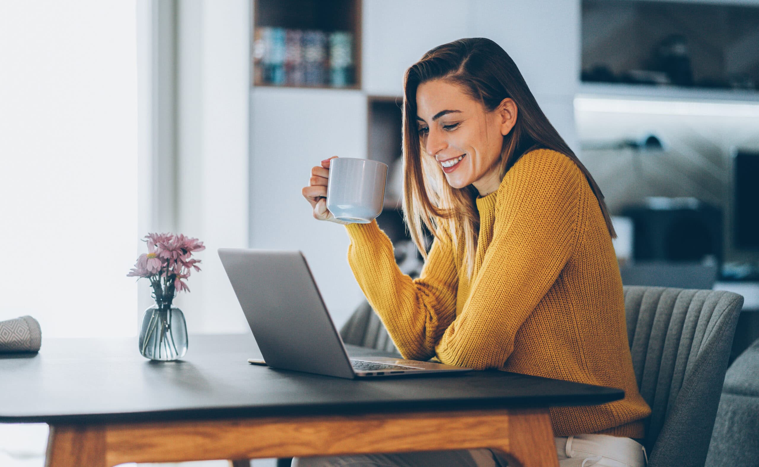 Young woman working at home, typing on laptop