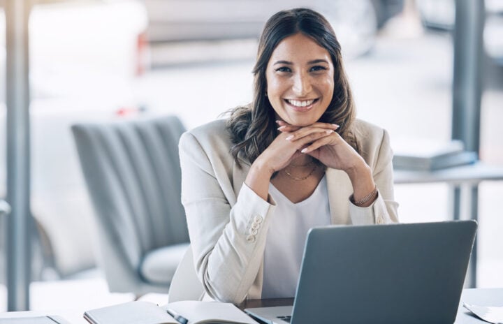 Woman, portrait and laptop in office planning, legal consulting or policy review feedback in corporate law firm. Smile, happy and attorney lawyer on technology in case research or schedule management