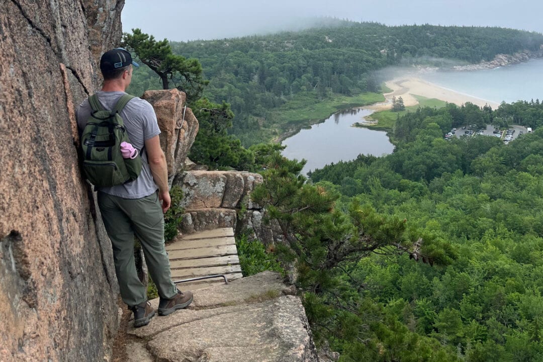 Hiking the Beehive Trail in Acadia National Park with views of Sand Beach and the coastline